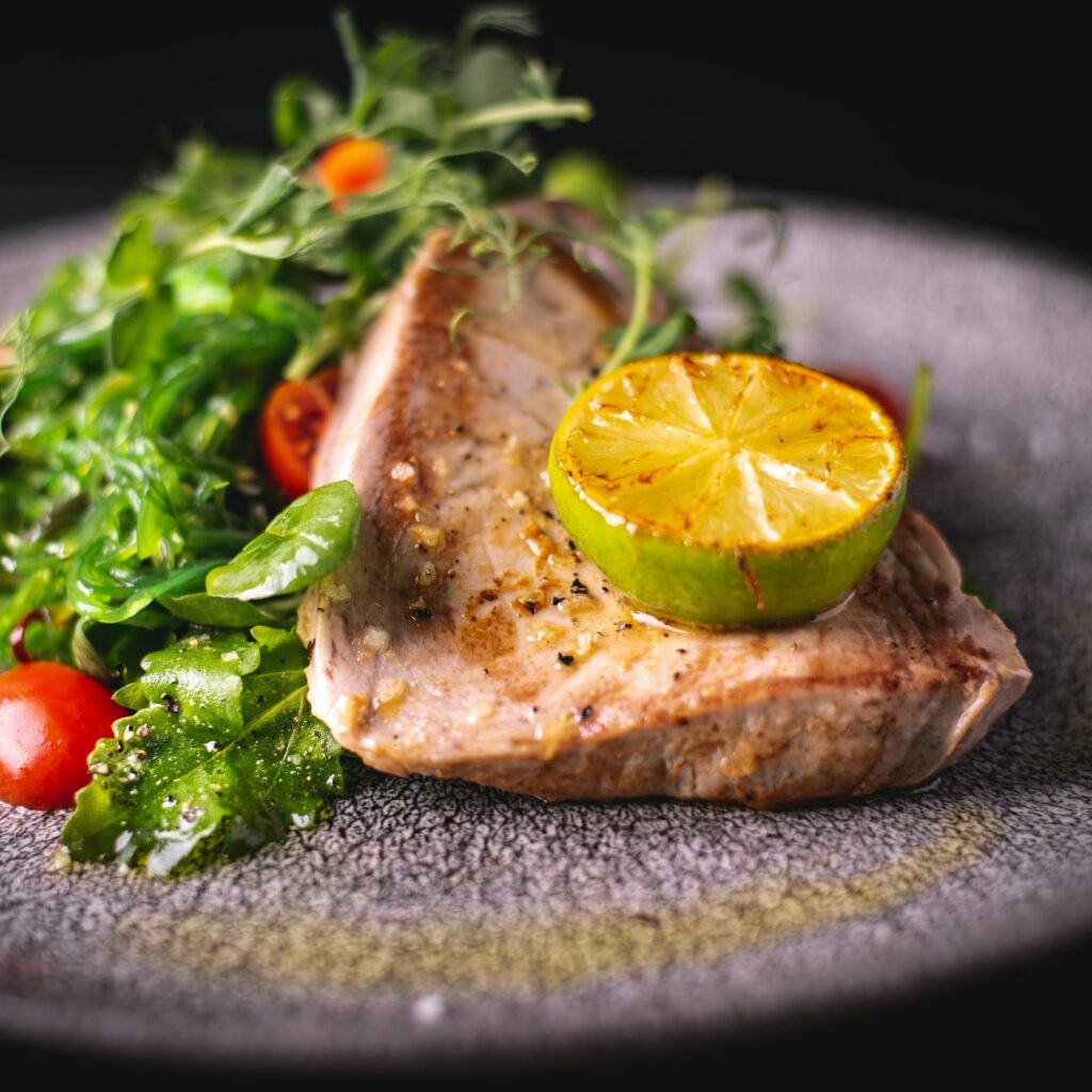 Steak z tuňáka sous vide podávaný s limetkou na salátu.