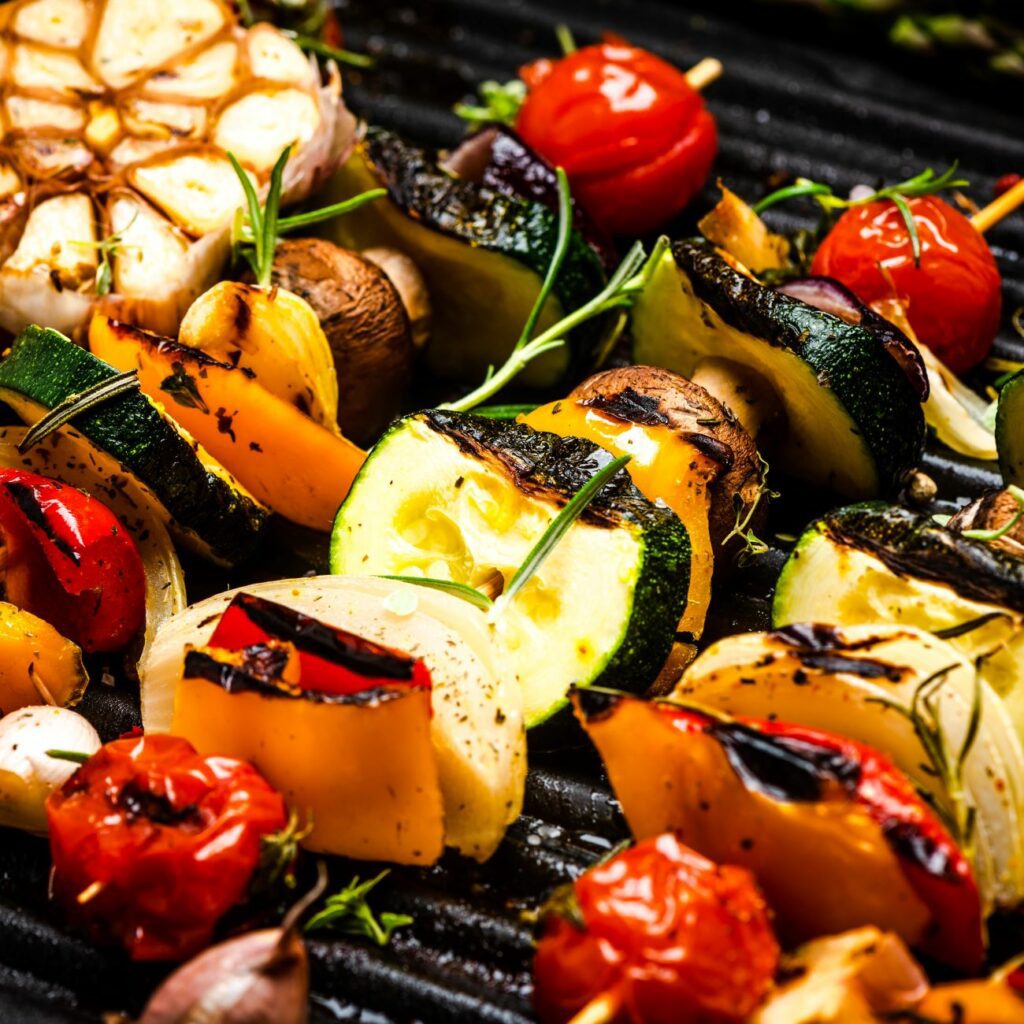 Gegrillte Gemüsespieße werden nah auf dem Grill gezeigt