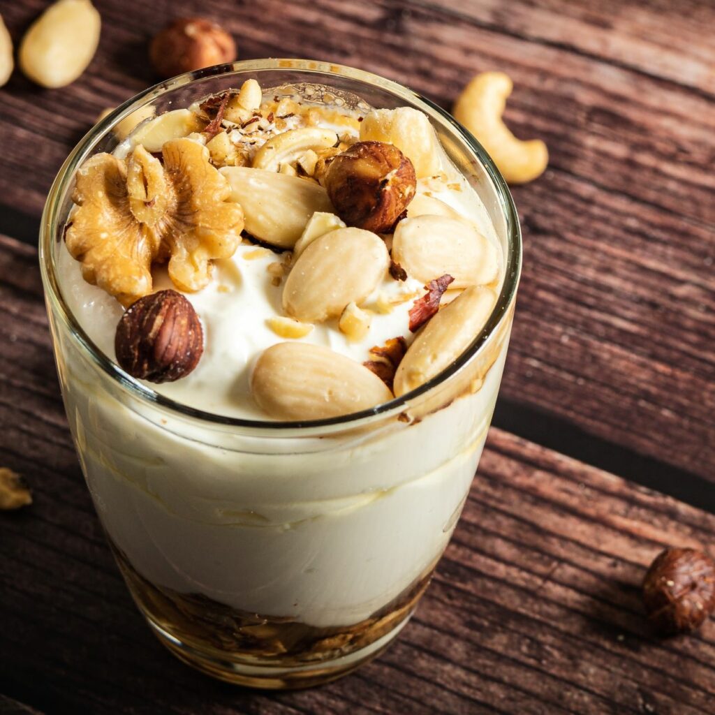Griechischer Joghurt mit Honig und Nüssen wir in einem Glas serviert.