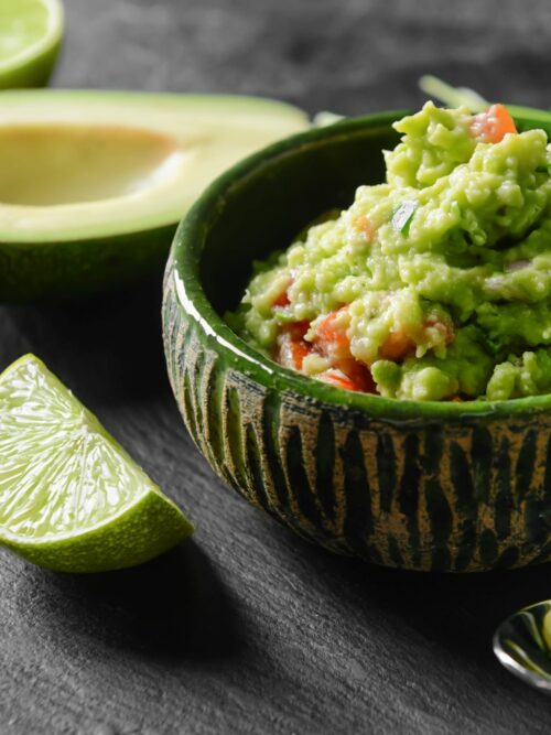 Guacamole wird in einer grüner Schale gezeigt.