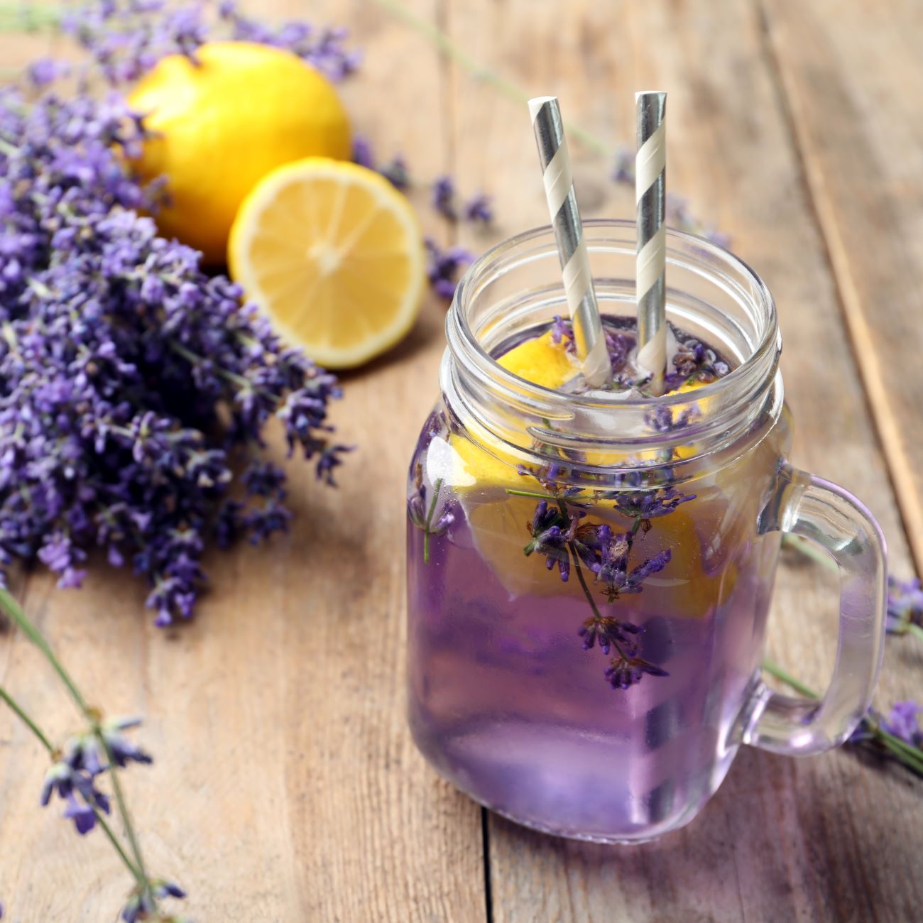 Lavendel-Limonade wird in einem Glas mit Henkel und Strohhalm serviert.