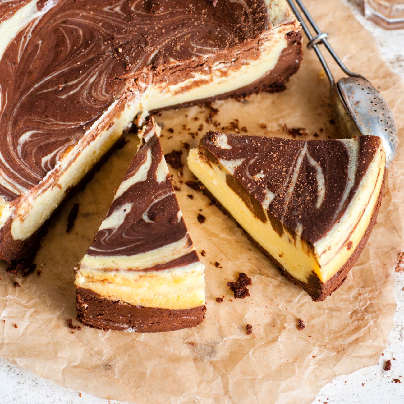 Mramorový cheesecake sa predkladá nakrájaný na papieri na pečenie.