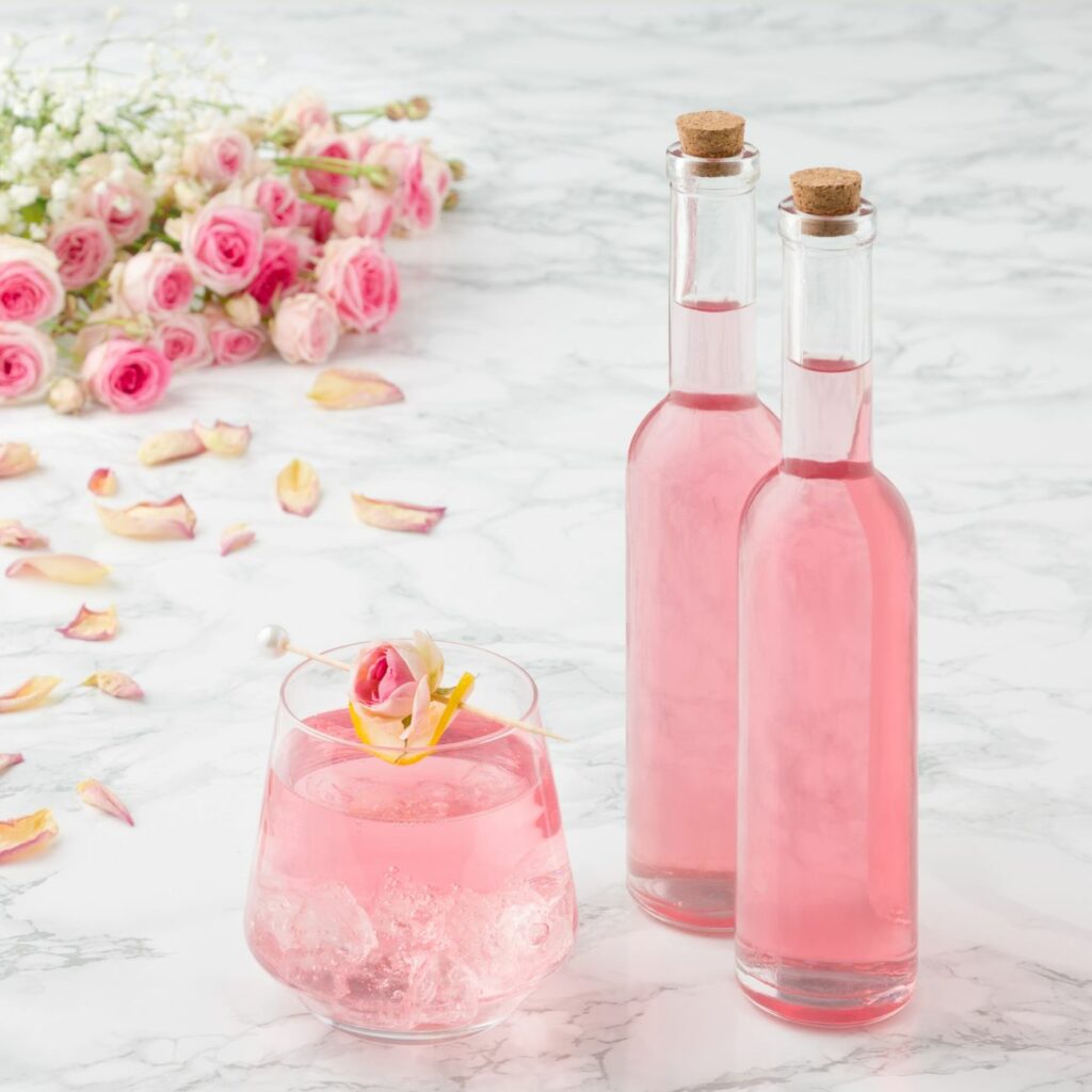Ružový sirup sa podáva v dvoch malých fľašiach a pohári s kockami ľadu.