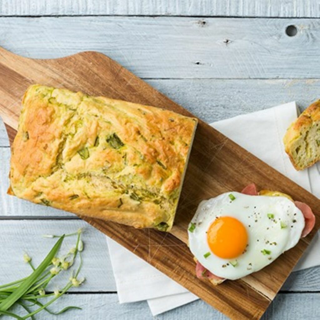 Spargelbrot wird auf einem Holzbrett mit einem belegten Stück gezeigt.