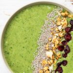 Green Smoothie Bowl wird in einer weißen Schüssel ganz nah gezeigt.