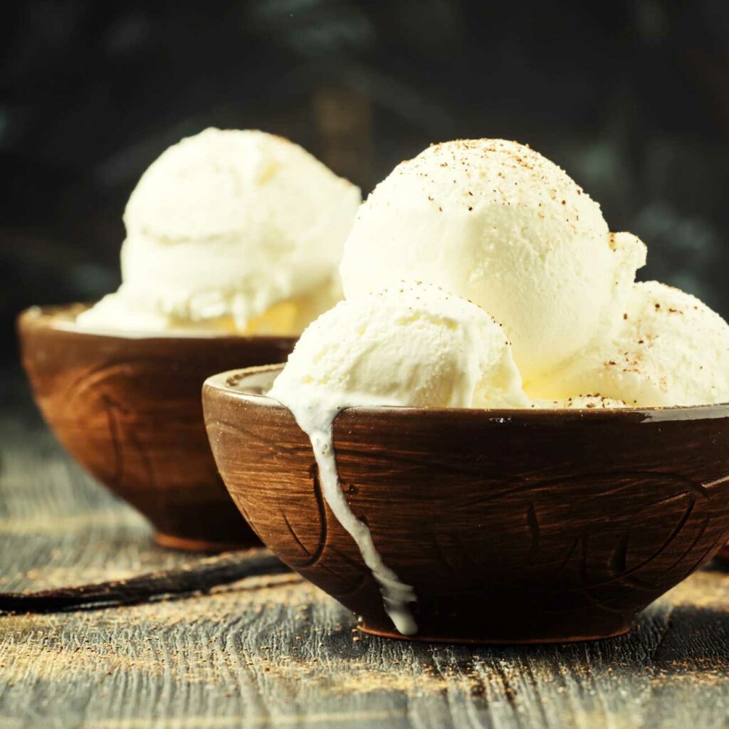 Veganski vanilijev sladoled je postrežen v dveh lesenih skodelicah.