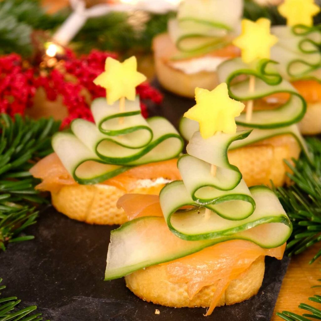 Lososové crostiny sa podávajú na bridlicovom tanieri s vianočnými ozdobami.