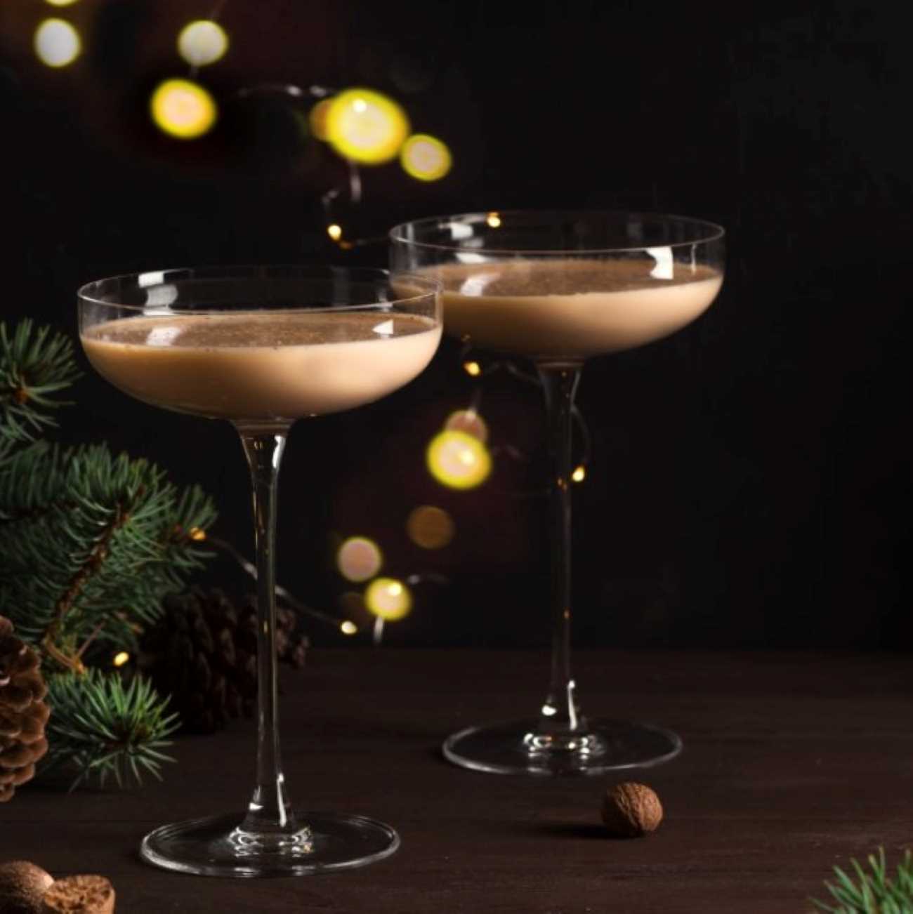 Brandy Alexander wird mit weihnachtlicher Deko und einem Cocktail-Shaker gezeigt.