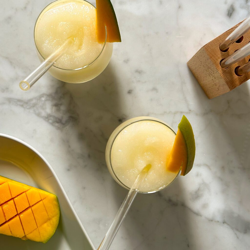 Mango Slush wird von oben mit Glasstrohhalmen gezeigt.