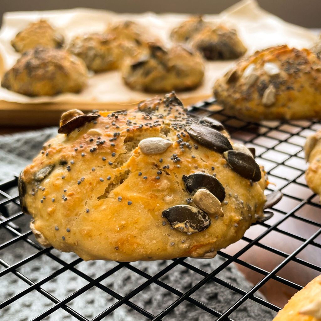 Brötchen ohne kneten werden auf einem Abkühlrost und in einem Brotkorb gezeigt.