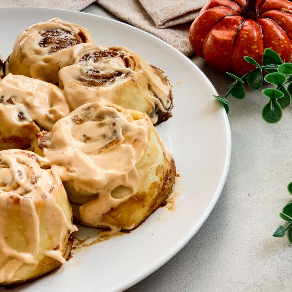 Pumpkin Cinnamon Rolls werden auf einem Teller gezeigt.